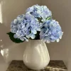 Beige vaas met blauwe kunst bloemen boeket